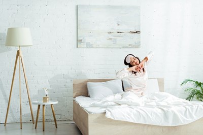 Frau erwacht morgens in ihrem Bett